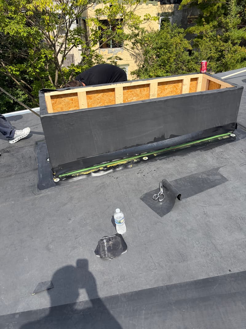 Flat roof curb framed in wood with black membrane