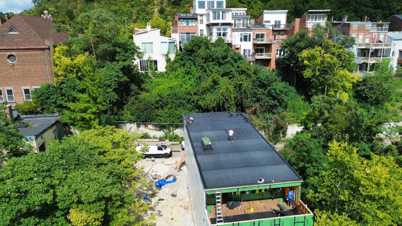 Aerial view of flat roof project among trees on hillside