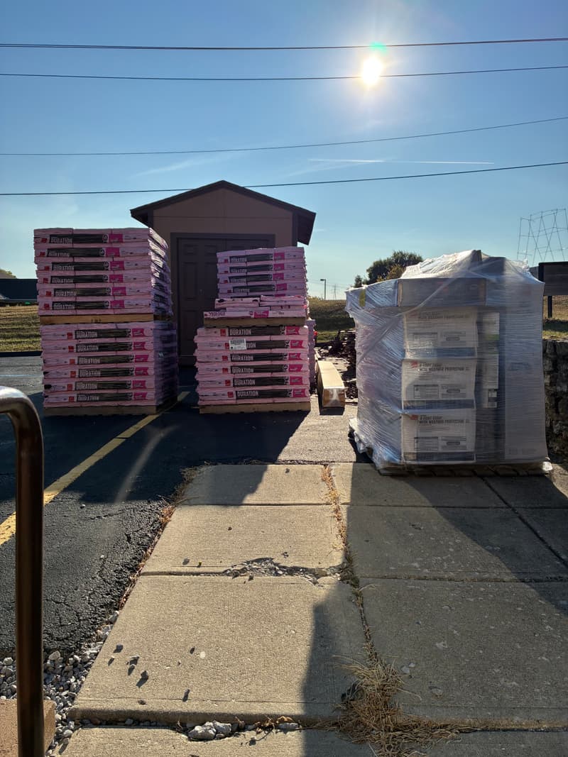 Pallets of roofing materials stacked in a yard