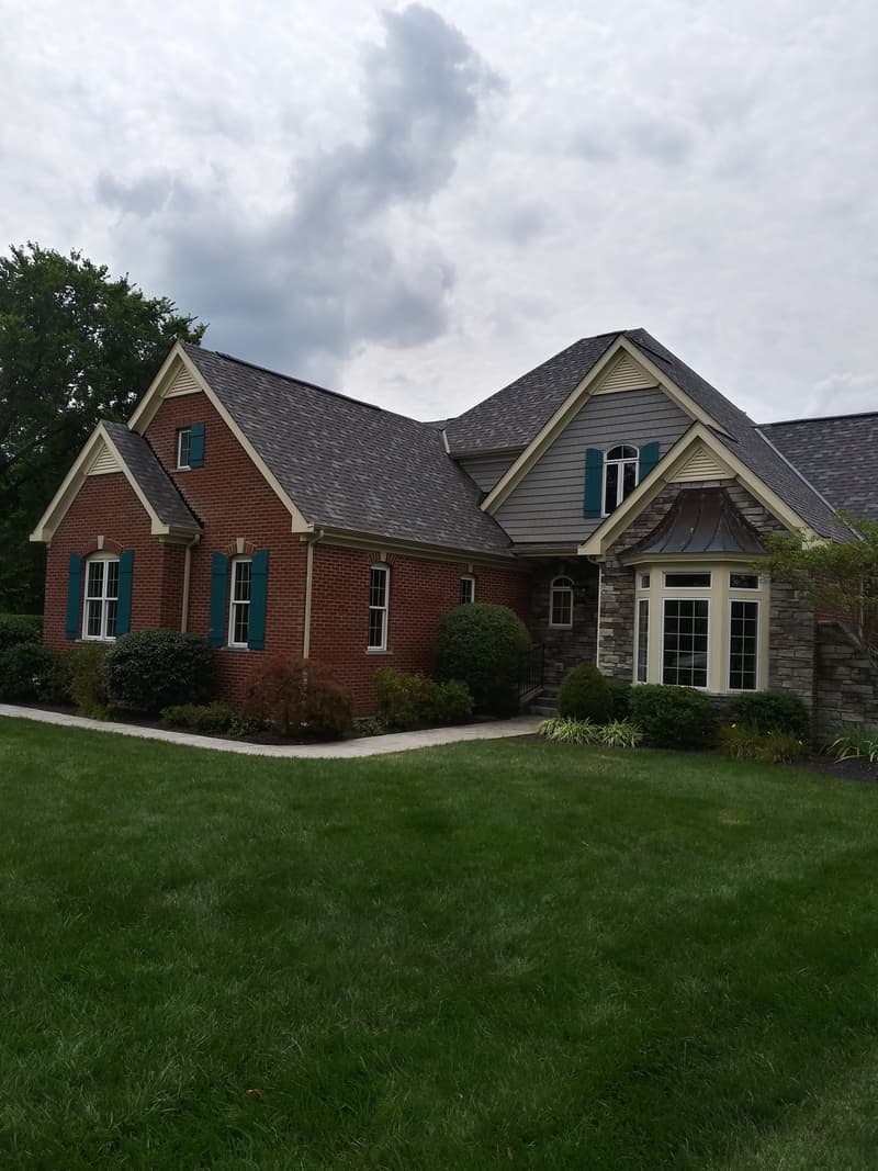 Brick house with newly shingled gray roof