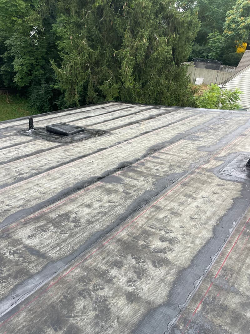Weathered flat roof with seams and a vent